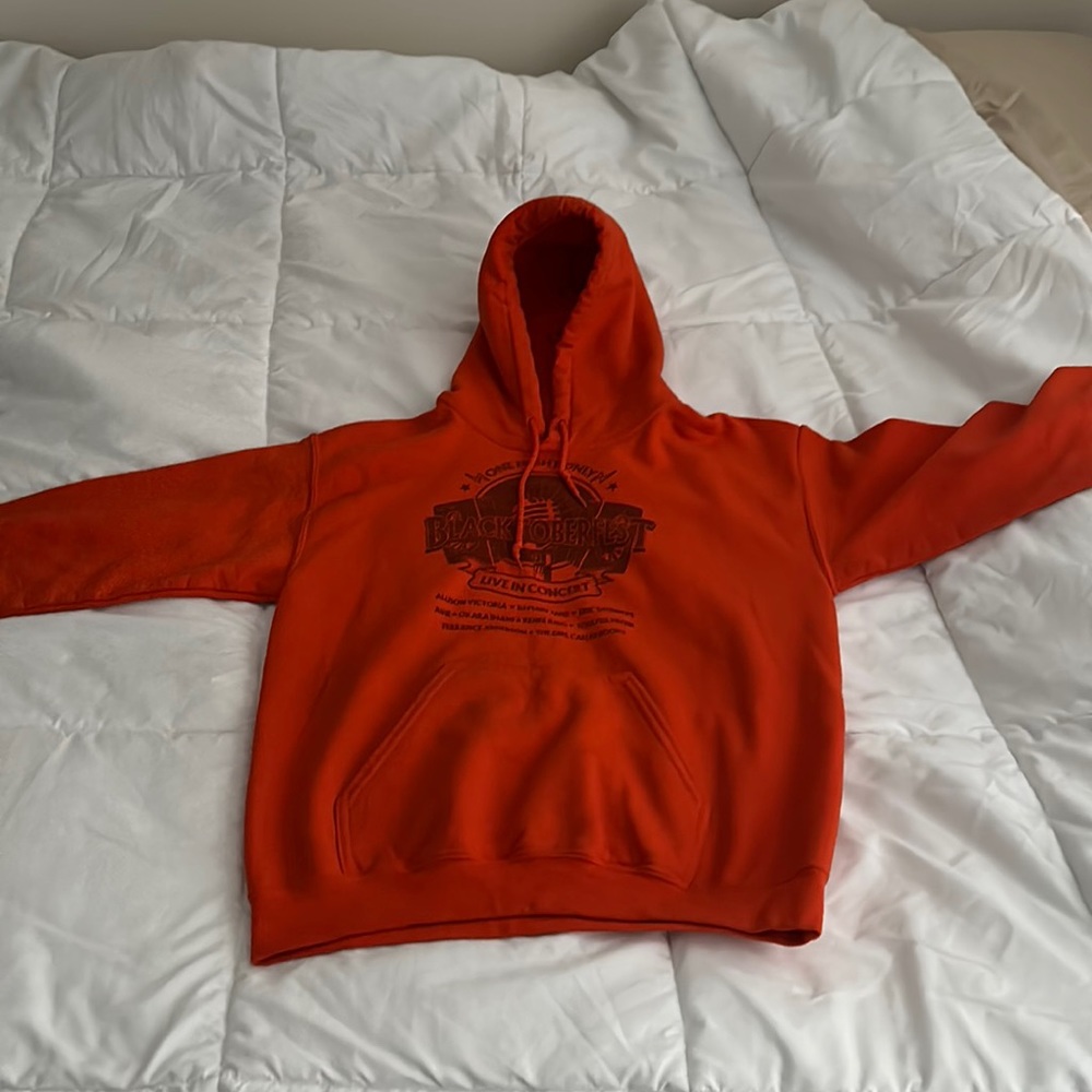 Orange “Blacktoberfest” hoodie with black design.